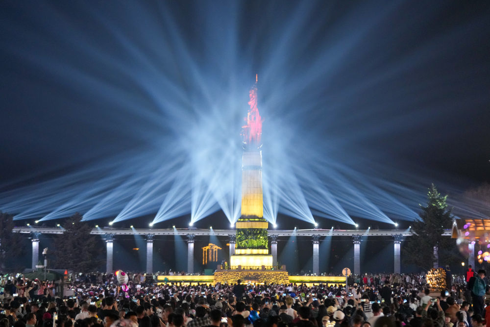5月3日，人们在哈尔滨防洪纪念塔广场观赏光影秀。