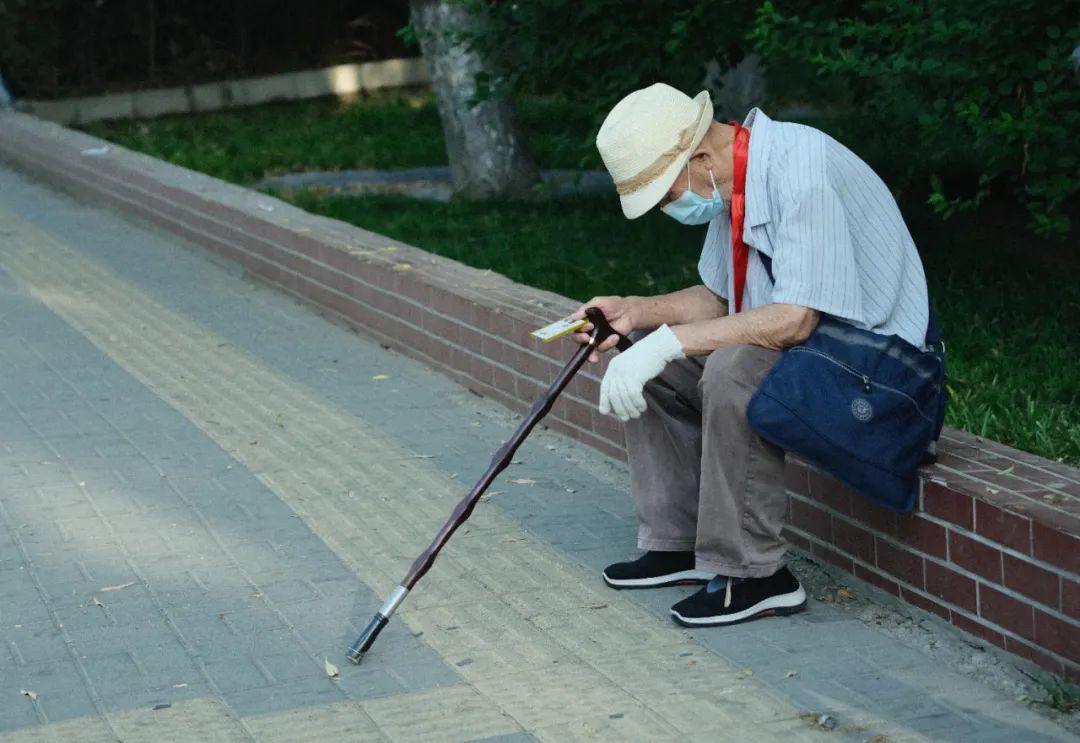 2023年7月1日,北京,马路边一位休息的老人。
