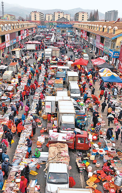 山东青岛市崂山区王哥庄年货大集上，人们逛集市、置办年货，在喜庆的氛围中迎接新春佳节。王海滨摄（新华社发）