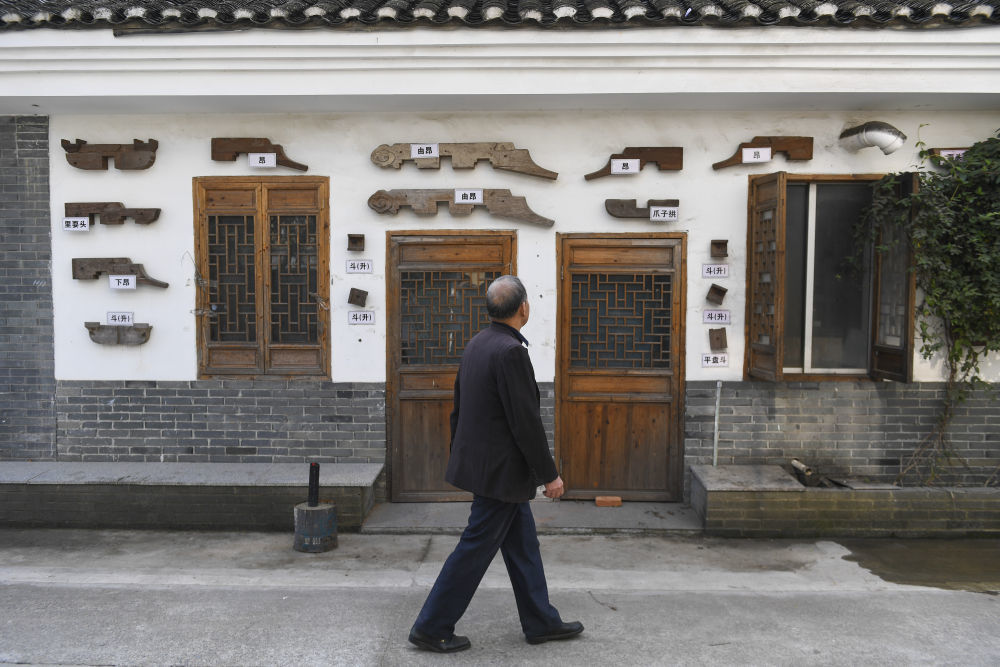 11月22日，黄大树走在浙江临海汇溪镇浚头村的古建工匠宣传廊前。