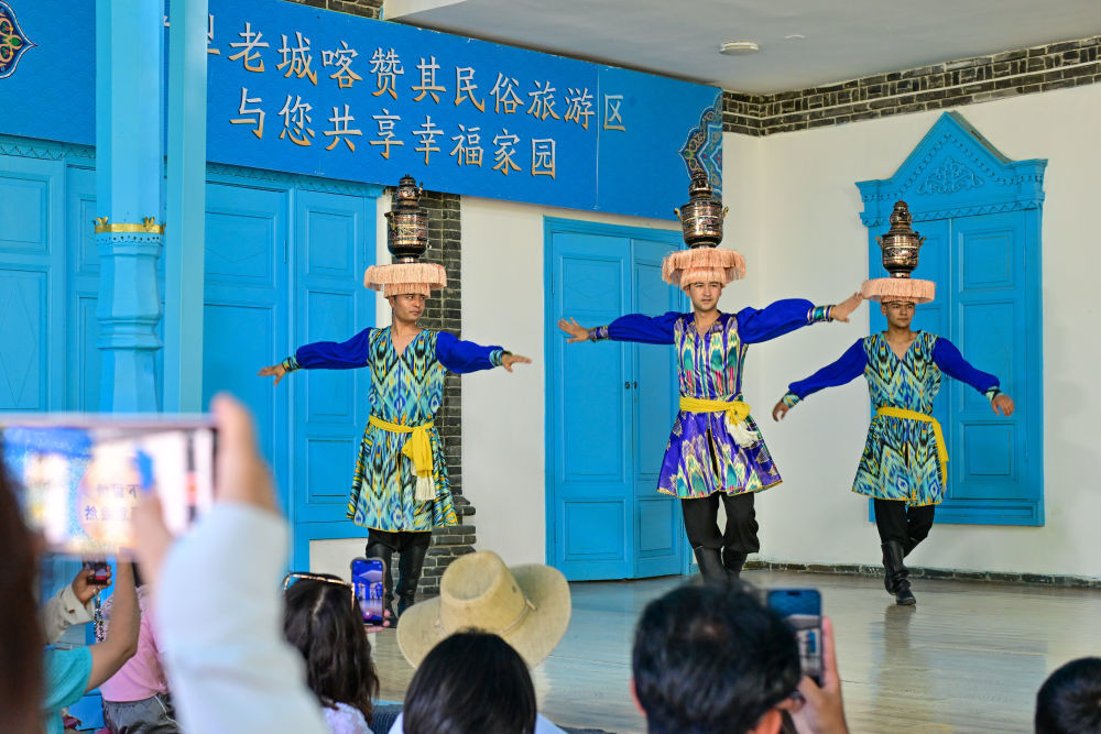 在伊犁哈萨克自治州伊宁市喀赞其民俗旅游区，游客在锡伯车马店欣赏文艺表演（7月27日摄）。