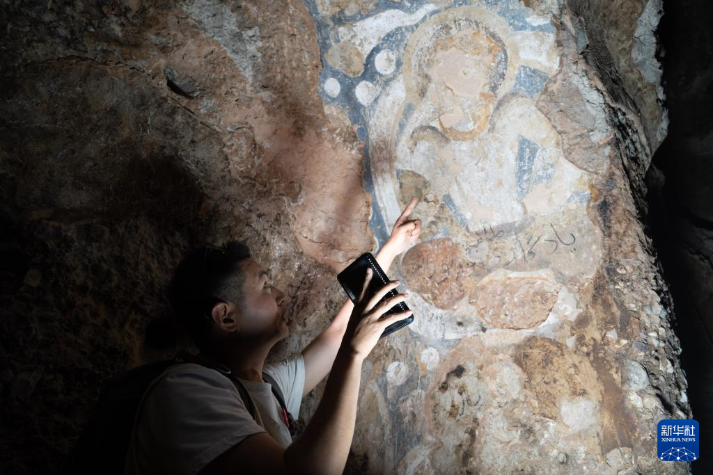 6月15日，在阿富汗巴米扬省，中国学者邵学成在一处石窟中观察壁画。新华社记者 赵家淞 摄
