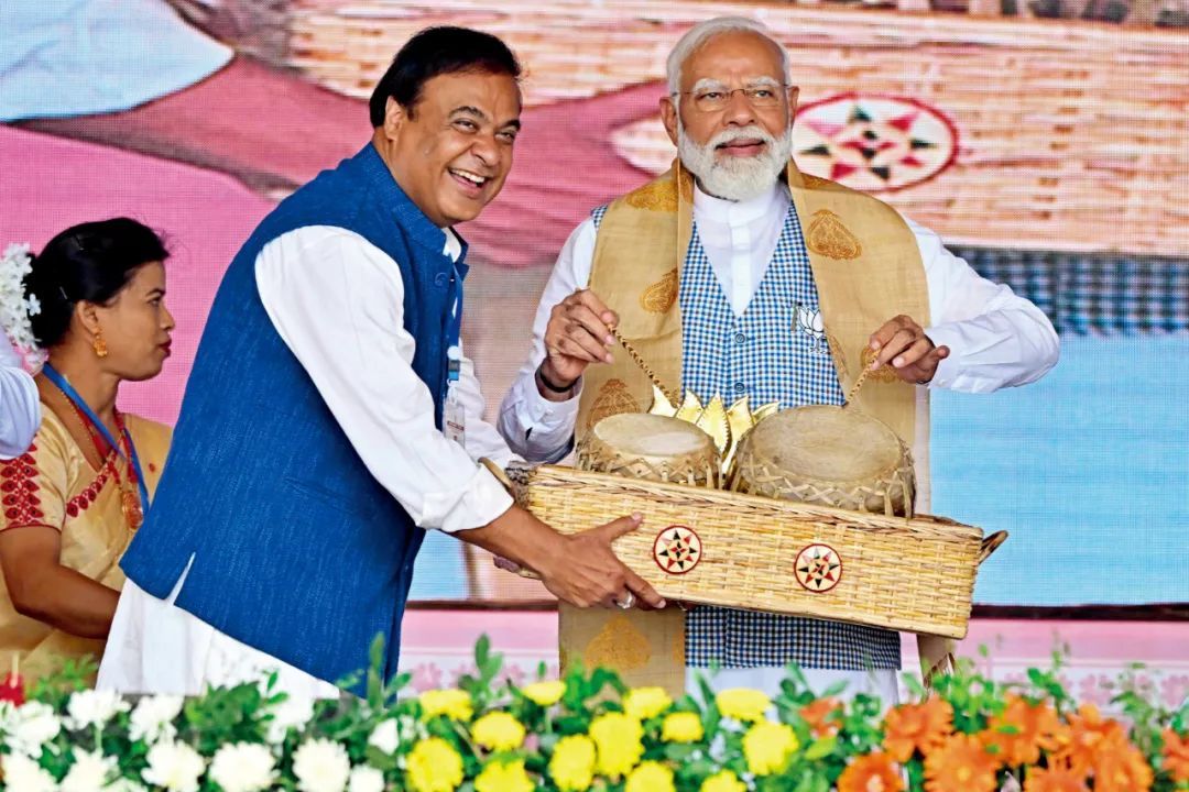 4月17日，印度阿萨姆邦，印度总理莫迪（右）在一场竞选活动中演奏传统鼓。图/视觉中国
