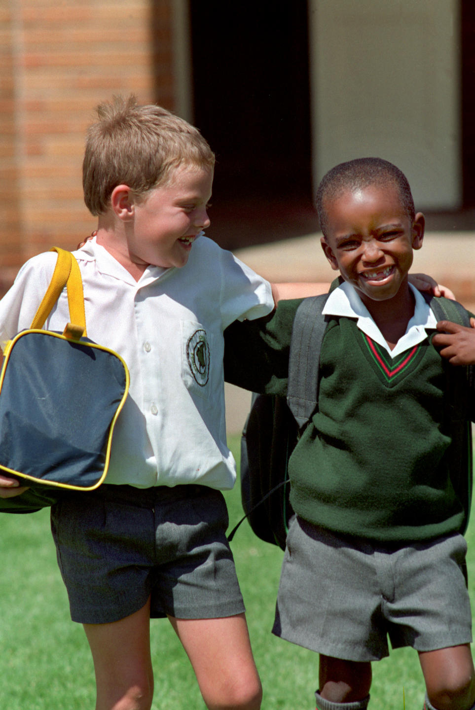 1995年，南非约翰内斯堡格林塞德小学不同肤色的学生放学后一起高高兴兴走出校门。当年，南非正式实行“自由的、不分种族的”教育制度。