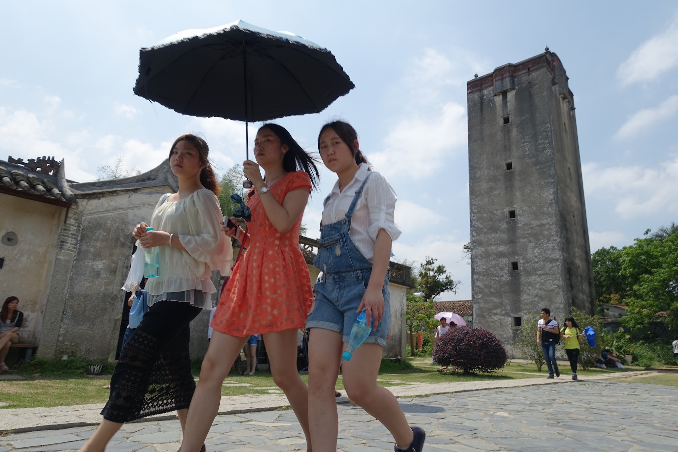 游客从深圳观澜镇版画村碉楼前走过。陈文 摄