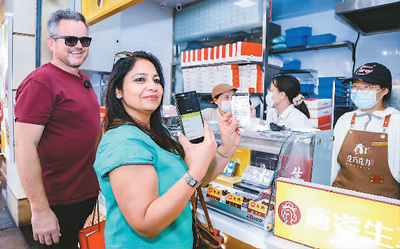 新西兰旅行商在上海用手机支付购买老字号点心。（照片由中旅旅行提供）