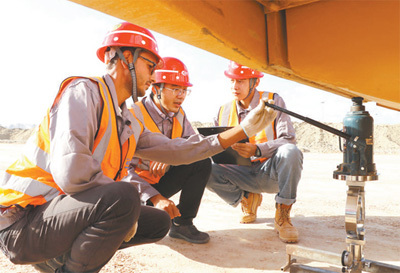 在阿布基尔集装箱码头项目,中方员工向埃方新入职员工(左)讲授级配碎石检测知识。史筱迪摄