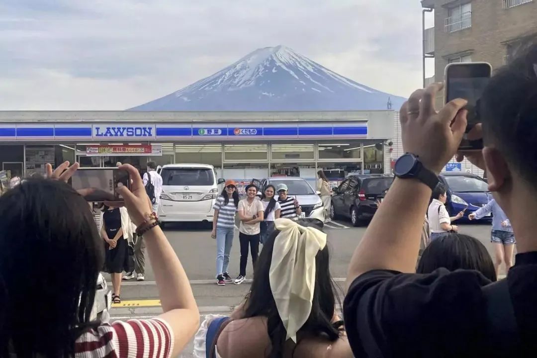 4月30日，一名保安在网红便利店附近的路障施工现场外提醒游客