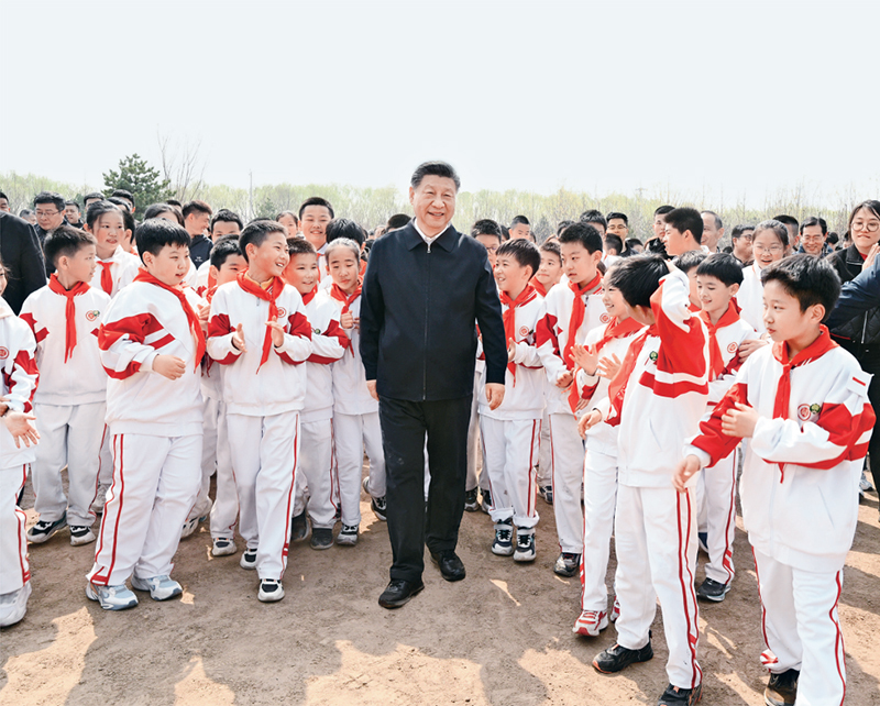 2024年4月3日,党和国家领导人习近平、李强、赵乐际、王沪宁、蔡奇、丁薛祥、李希、韩正等来到北京市通州区潞城镇参加首都义务植树活动。这是习近平同少先队员在一起。 新华社记者 李学仁/摄