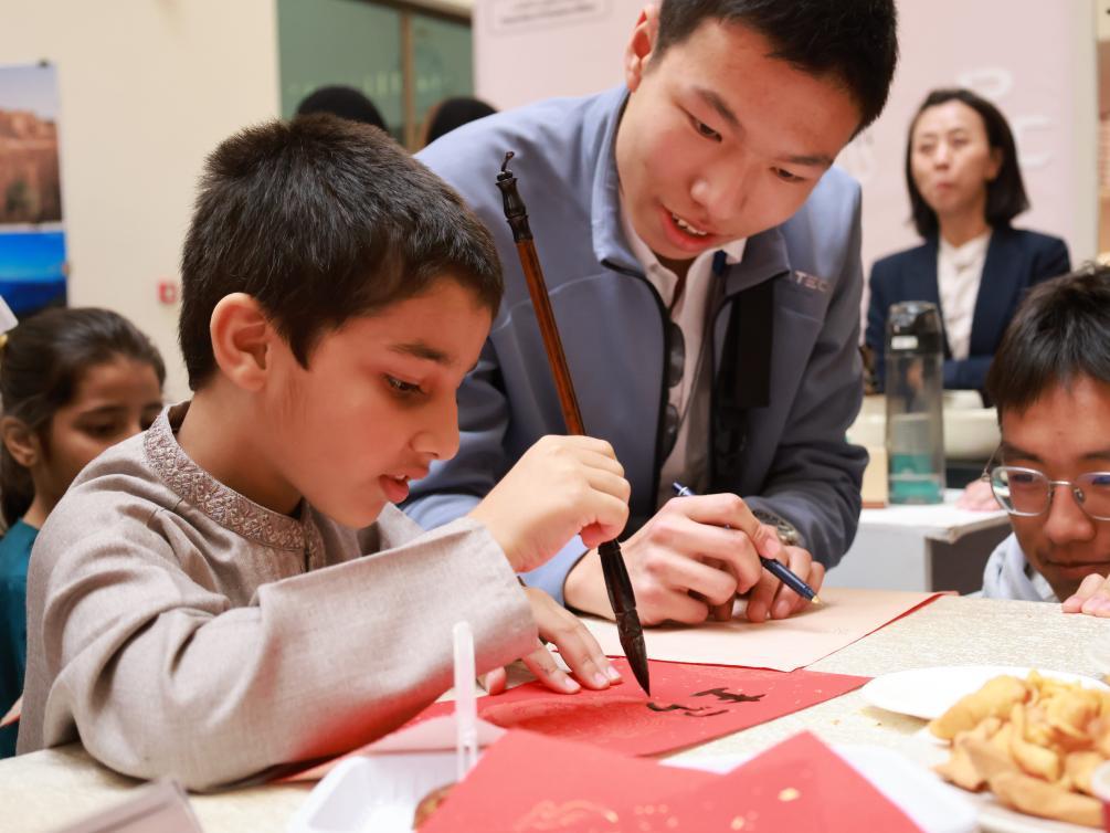 1月29日，在沙特阿拉伯首都利雅得的苏尔坦亲王大学，一名儿童在孔子学院展位体验中国书法。新华社记者王海洲摄