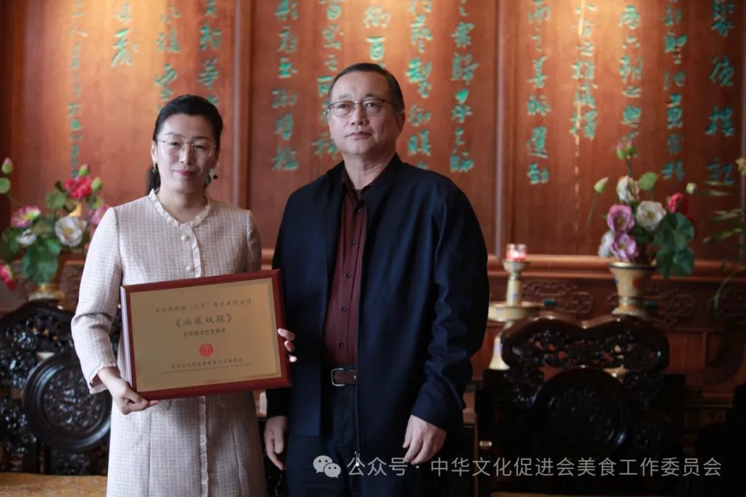 中华文化促进会美食工作委员会专家评审委员胡越先生为聚德楼总经理张禹珊女士授“百年味道技艺传承”铜牌