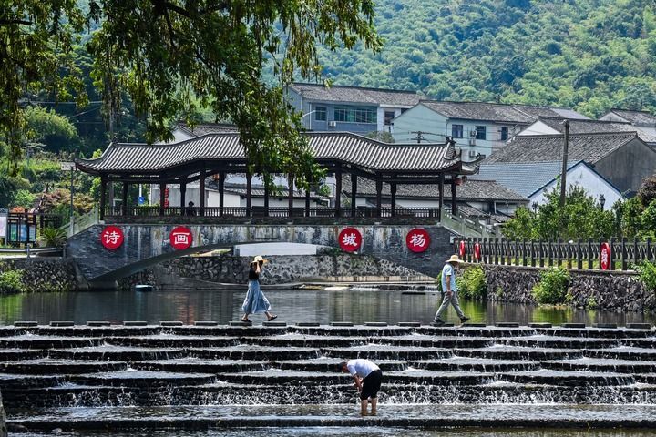 游客在浙江宁波市鄞州区城杨村的溪流游玩（2024年8月10日摄）。新华社记者 徐昱 摄