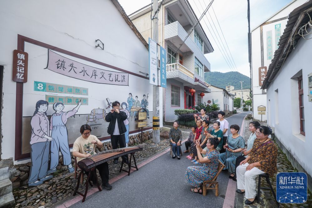 6月15日，杭州师范大学音乐学院的学生（左一、左二）在三都镇镇头村为村民即兴演出。