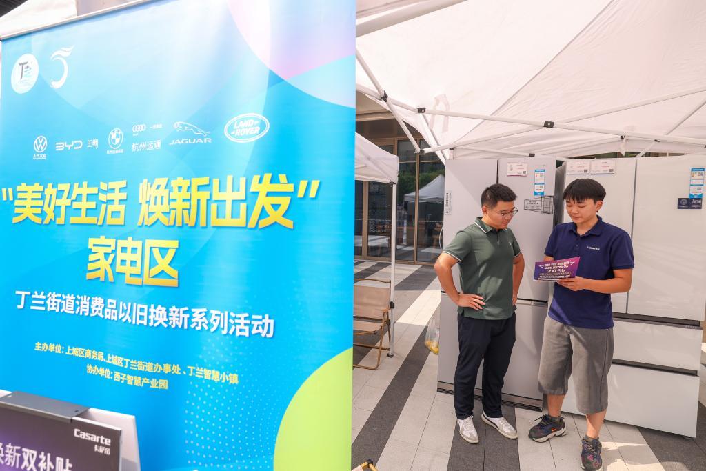 9月27日，在浙江省杭州市上城区丁兰街道，消费者（左）在“美好生活 焕新出发”消费品以旧换新展会现场咨询家电。新华社记者 江汉 摄