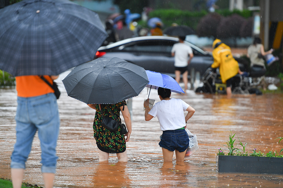 6月24日，在长沙市雨花区万家丽中路附近，市民涉水通行。当日，受强降雨影响，湖南省长沙市部分地段出现内涝。目前，长沙市已经启动防汛三级应急响应。新华社记者 陈泽国 摄