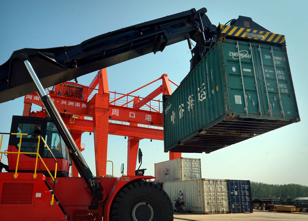 2020年8月27日，工人操作机械设备在河南周口中心港码头进行吊装作业。