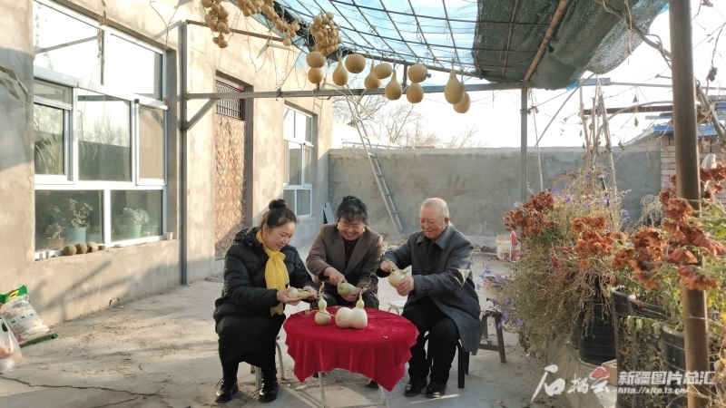 11月2日，帕提古丽·艾沙（左）、陈新萍（中）和托合地·吾守（右）正在院子里给葫芦去皮，等晾干以后制作手工艺品。阿依古丽·库完摄