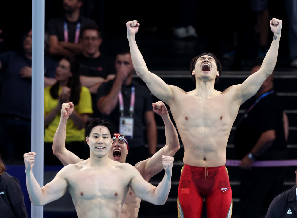 8月4日,中国队选手覃海洋、孙佳俊、徐嘉余(从左至右)在夺冠后庆祝。当日,在巴黎奥运会游泳项目男子4X100米混合泳接力决赛中,中国队夺得金牌。新华社记者 雒圆 摄