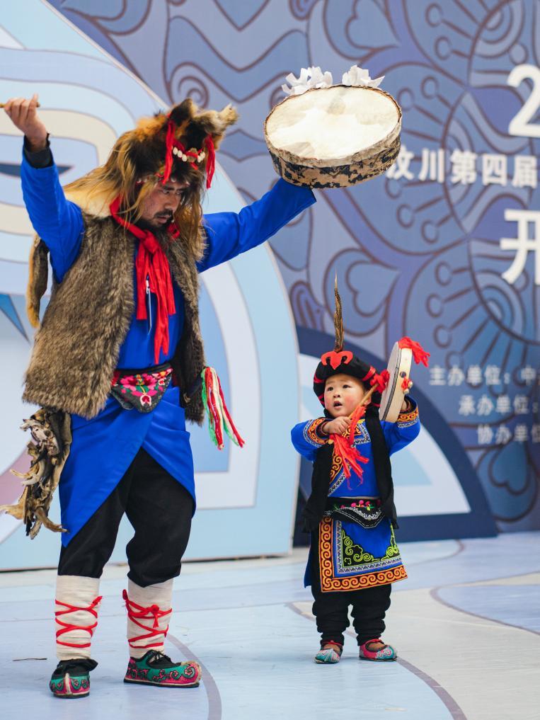 在汶川县第四届羌族传统体育运动会上，小耶格和舅爷赵俊成表演羊皮鼓舞（2023年2月16日摄）。