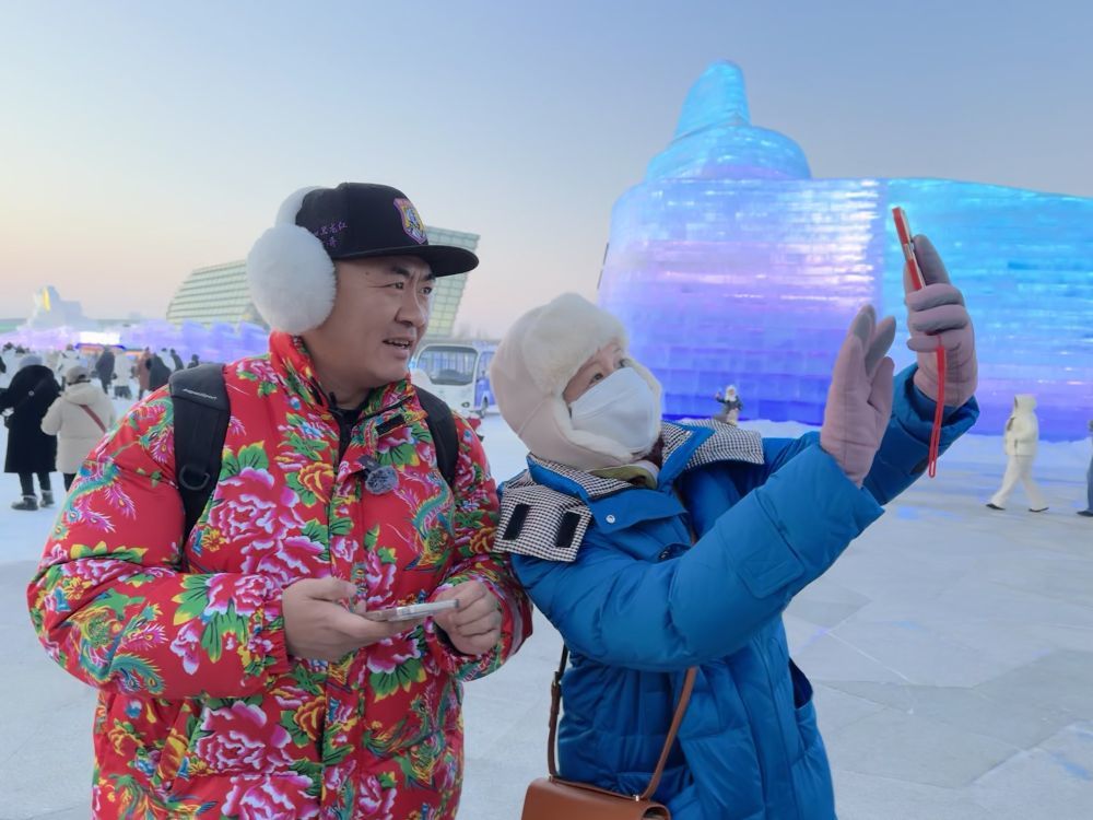 1月9日，在哈尔滨冰雪大世界，腾越（左）与游客合影。新华社记者 杨思琪 摄