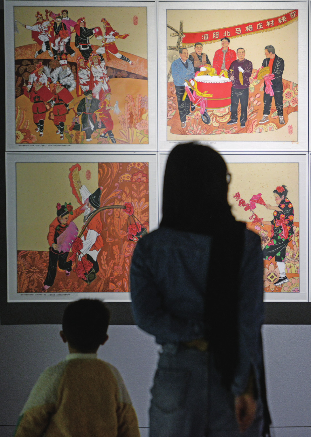 2023 年2月22日,重庆。一对母子正在重庆美术馆观看连环画展。(图/何蓬磊 中新社 )