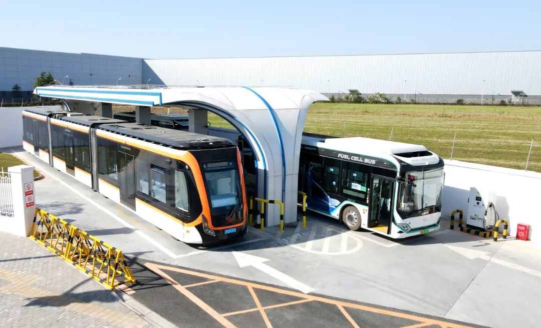 一辆氢能中运量公交车（左）驶入氢能公交车加气站（无人机照片）。方喆 摄（新华社）