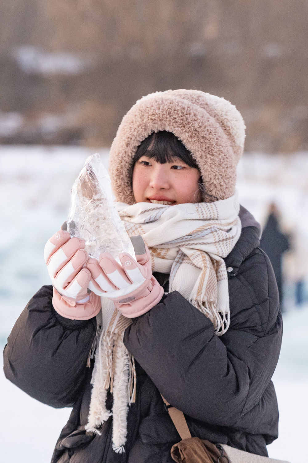 1月7日，在封冻的松花江哈尔滨段，游客在“钻石海”拾起一块“碎钻”。新华社记者 谢剑飞 摄