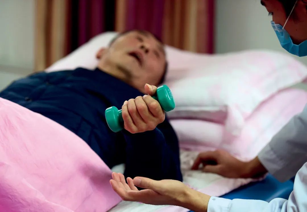 2018年12月4日,河北泊头市福星园老年公寓,护理人员帮助失能老人进行康复训练。本文图/新华