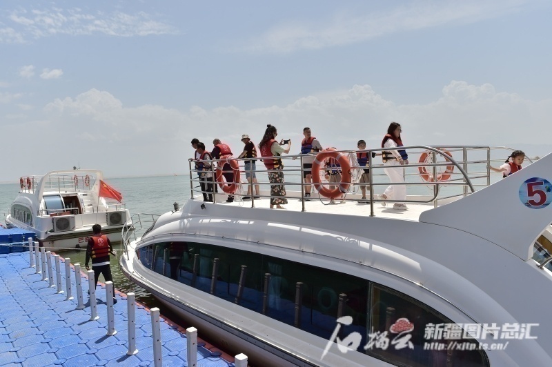 △6月15日，游客在博斯腾湖景区乘坐游艇游玩。石榴云/新疆日报记者 王立华摄