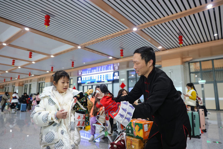 2024年1月26日，布袋木偶戏表演人员在福厦高铁泉州南站候车室与小朋友互动。新华社记者 周义 摄
