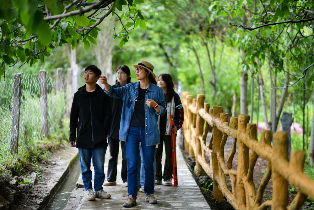 长江大学核桃科技特派团的刘利平博士（前）在加查县安绕镇热果村古核桃树下给学生开展现场教学（2023年7月27日摄）。长江大学核桃科技特派团在西藏山南市加查县创建核桃研究所，刘利平博士是团队的一员，主导实施了高原核桃产业技术研究项目的大部分工作。新华社记者 姜帆 摄