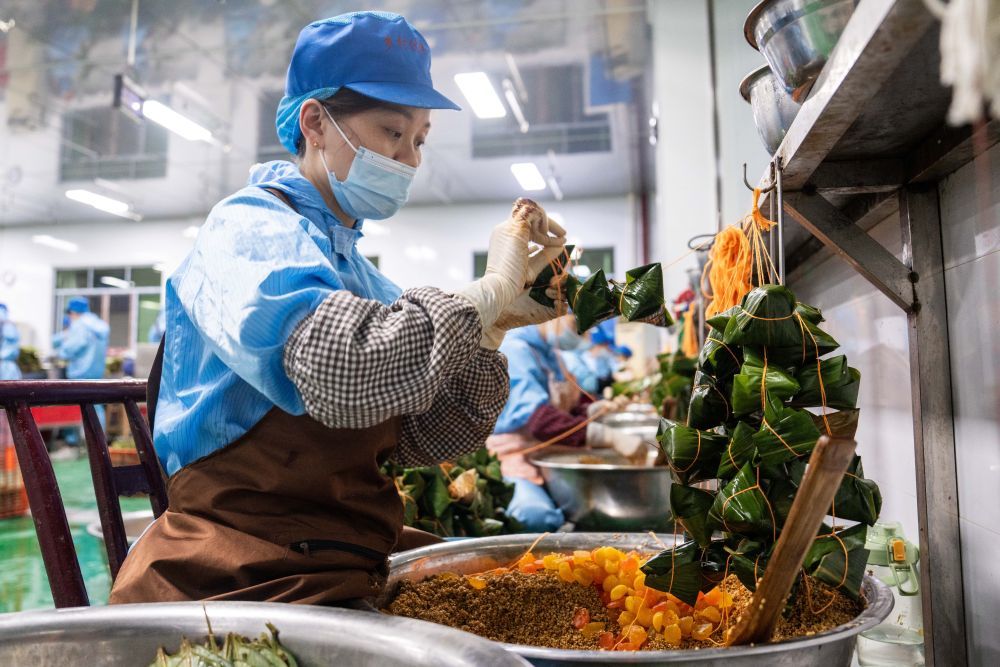 6月5日，在浏阳市关口街道道源湖村一家粽子生产车间，工人在包粽子。