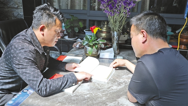 谢军成（右）与村干部一起开展理论学习。