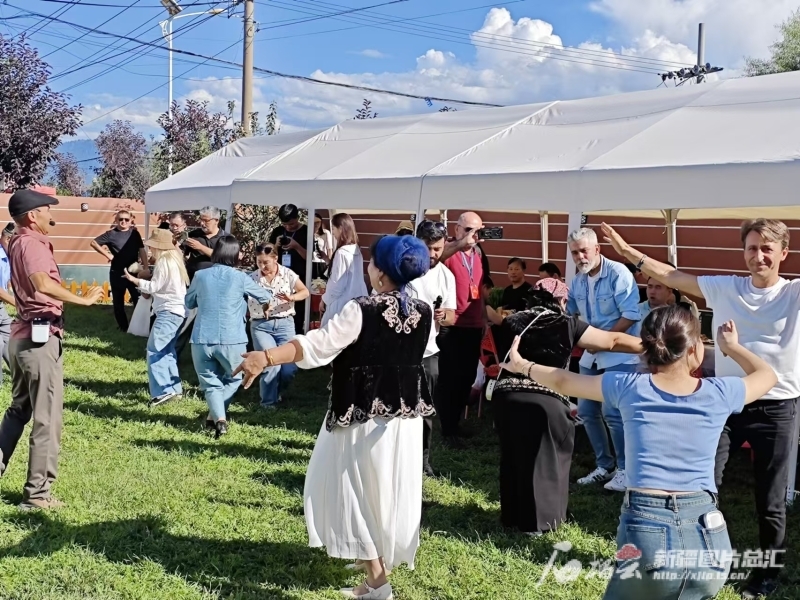土耳其媒体人士在新源县那拉提镇英加尔村与村民同跳新疆舞。石榴云/新疆日报记者 宋海波摄