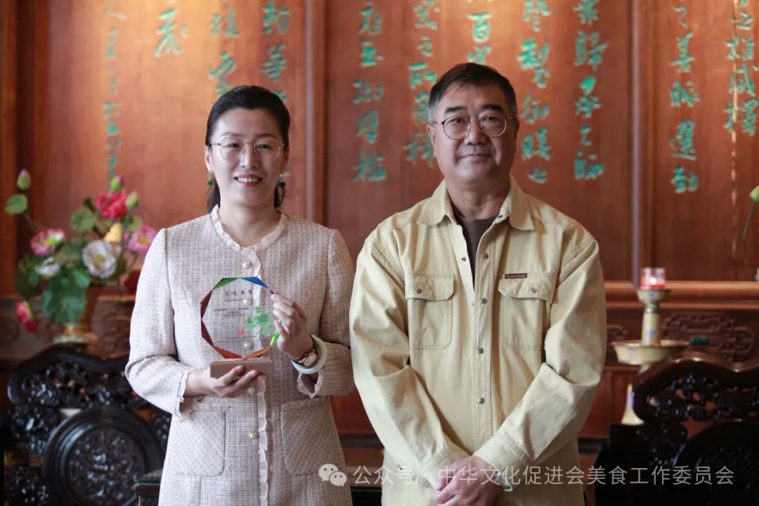 中华文化促进会驻会副主席陈钢先生为聚德楼总经理张禹珊女士授“百年味道技艺传承”水晶牌