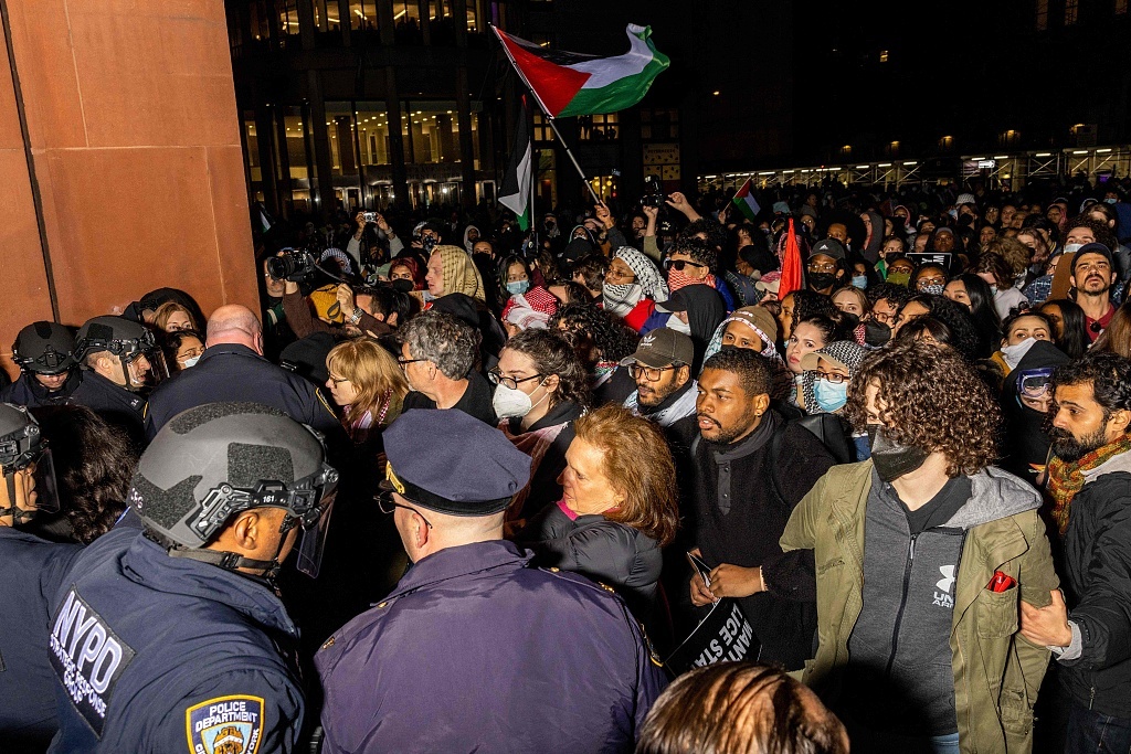 当地时间2024年4月22日，美国纽约，警察拘留了在纽约大学校园内设立营地抗议巴以冲突的亲巴勒斯坦学生和抗议者。视觉中国 图