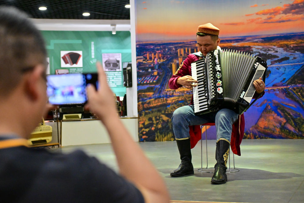 在伊犁哈萨克自治州伊宁市六星街，游客在亚历山大手风琴珍藏馆欣赏手风琴表演（7月27日摄）。