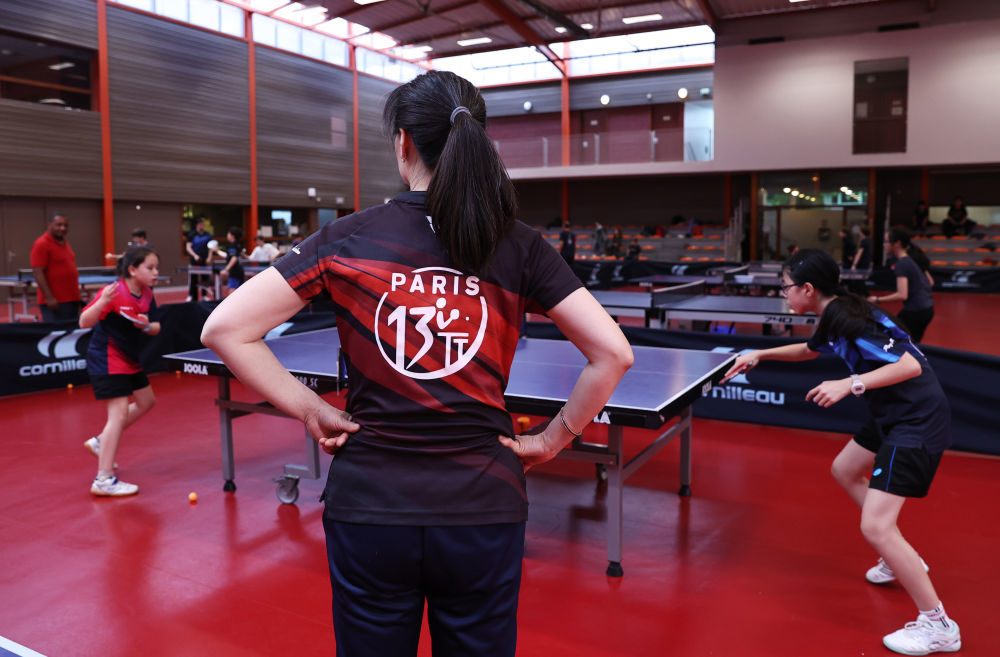 2024年6月19日，刘芳（中）在法国巴黎十三区乒乓球俱乐部上课。