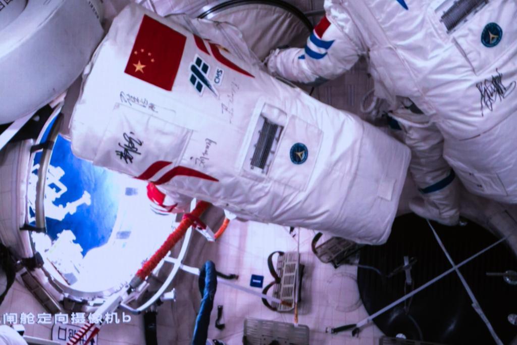 2023年12月21日在北京航天飞行控制中心拍摄的神舟十七号航天员汤洪波（左）开启问天实验舱气闸舱出舱舱门的画面。
