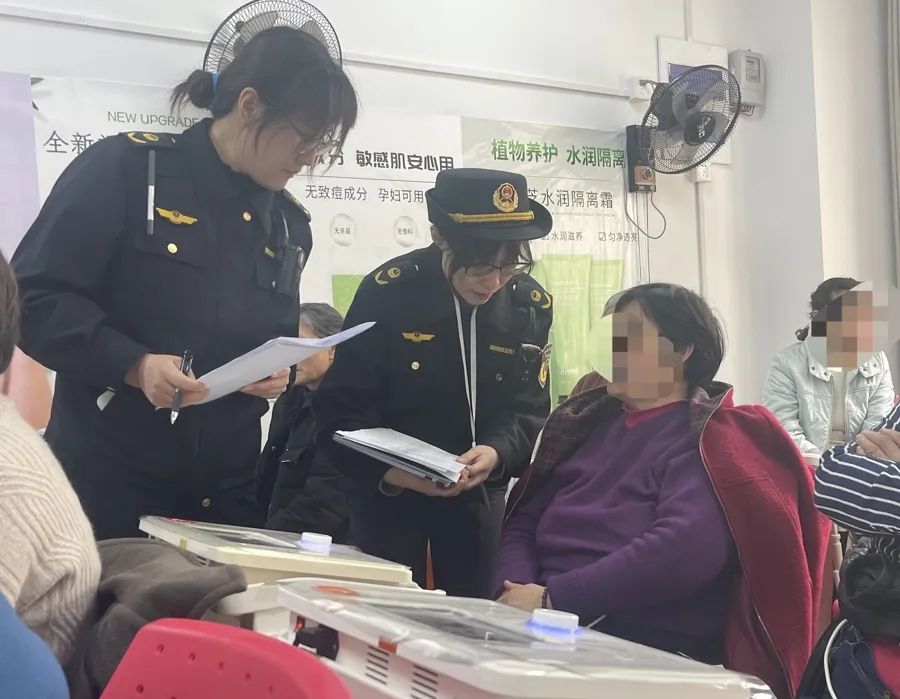 执法人员和现场体验“神器”的消费者进行交流。