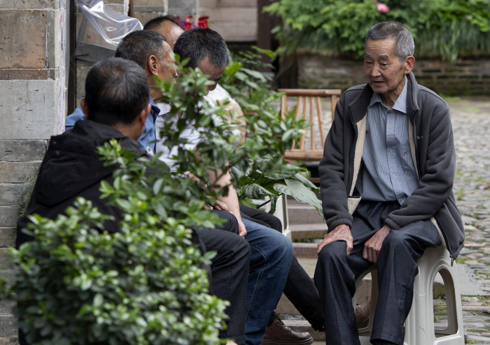 居住在泰宁县尚书巷历史文化街区内的老人们聚在一起聊天（4月19日摄）。