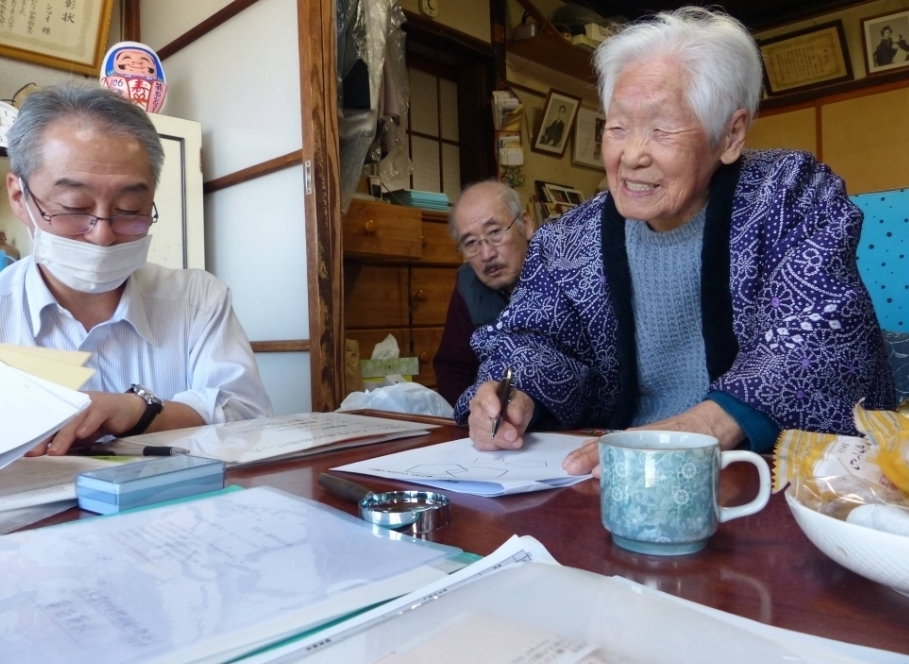 107岁的箱石室井（左）与讲论东讲念主员交讲。