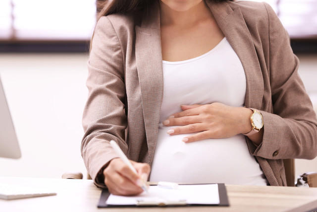 办公室办公桌前工作的年轻孕妇，特写,Young pregnant woman working at desk in office, closeup.jpg