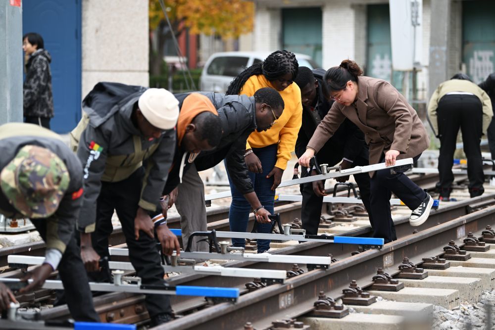 11月11日，在天津铁道职业技术学院，老师指导几内亚学员使用铁路轨距尺。（李然 摄）