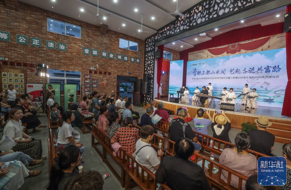 6月15日，村民们在建德市三都镇镇头村文化礼堂内观看杭州师范大学音乐学院学生与村民乐队表演。