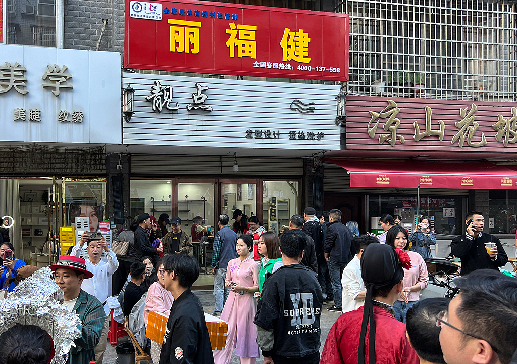 2024年11月9日，湖南省怀化市鹤城区靓点理发店，人民理发师晓华走红，莫名而来的市民集聚在理发店前打卡的热闹景象。（视觉中国）