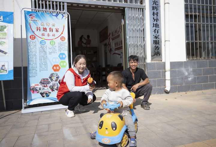 在宁夏青铜峡市瞿靖镇光辉村“异地有家”服务站，工作人员与来自云南的苗族务工人员杨正昌（右）的孩子玩耍（2024年8月23日摄）。新华社记者 杨植森 摄