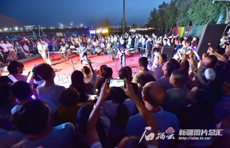 6月15日晚，库尔勒市鸿雁河广场，市民和游客在观看音乐会演出。石榴云/新疆日报记者 王立华摄