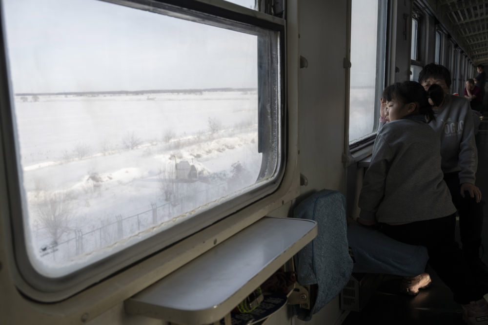1月23日，邪在哈我滨谢至抚遥的K7065次列车上，别号返乡女童视腹窗中的皎皎皂雪。