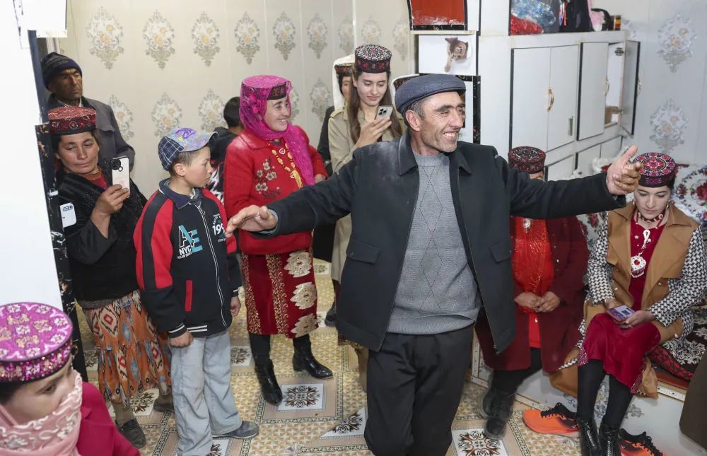 在位于新疆塔什库尔干塔吉克自治县瓦恰乡夏布孜喀拉村的家中，父亲多力开·百尔飞克跳起舞蹈庆祝女儿回家探亲。